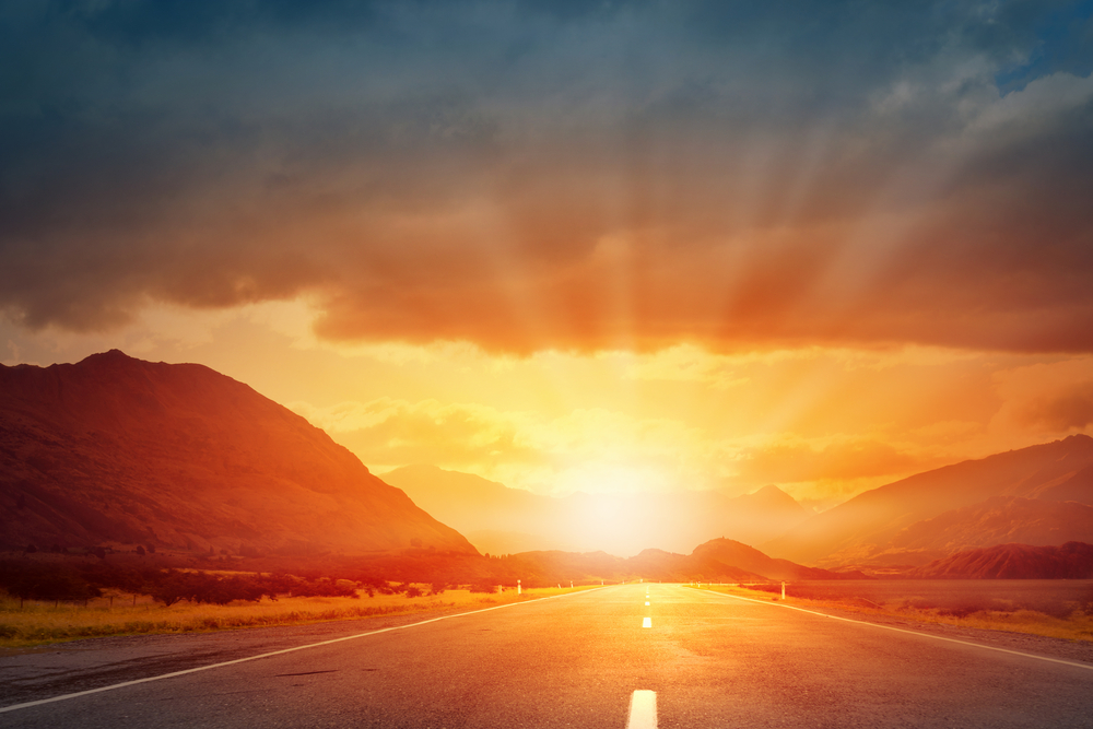 Empty asphalt road and sun rising at skyline