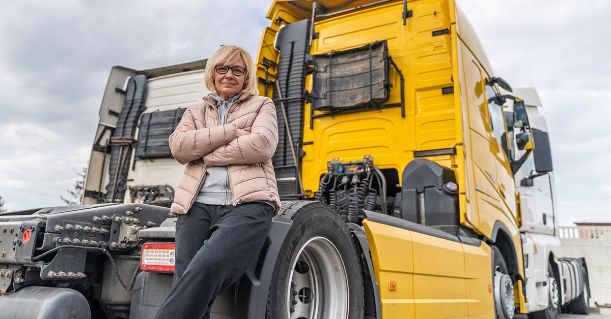 female-driver-standing-yellow-truck-1200x628